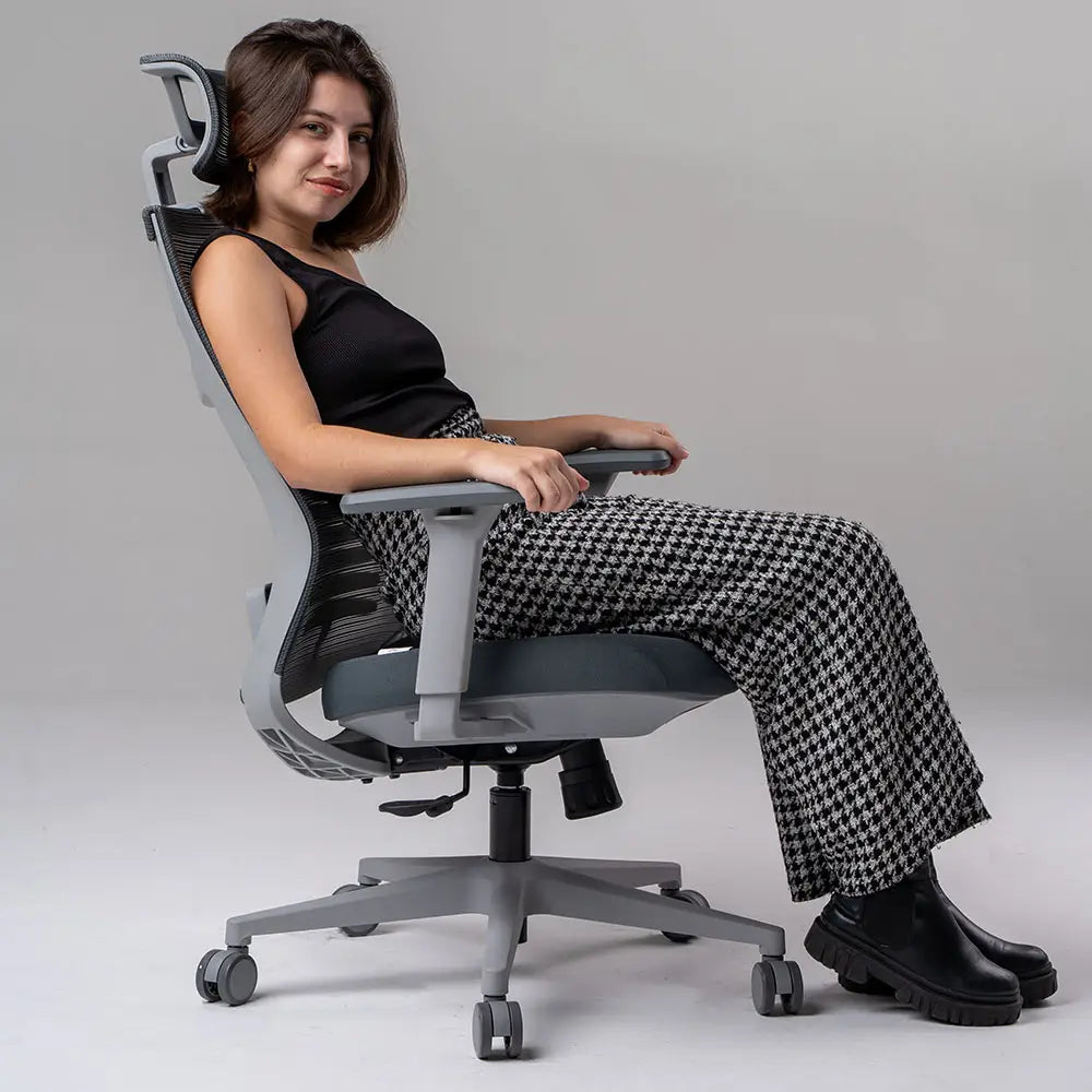 a imagem mostra uma Cadeira ergonômica de escritório Vertta  com revestimento do encosto em mesh e assento de espuma injetada, apoio de braços ajustáveis e base com rodízios, na cor cinza.