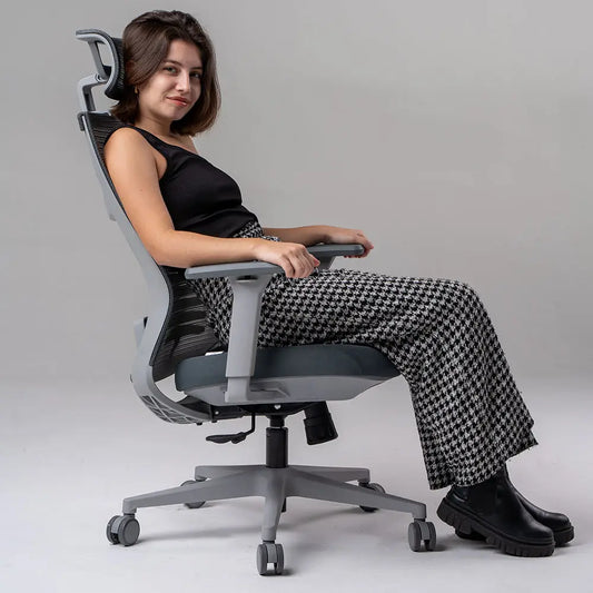 a imagem mostra uma Cadeira ergonômica de escritório Vertta  com revestimento do encosto em mesh e assento de espuma injetada, apoio de braços ajustáveis e base com rodízios, na cor cinza.
